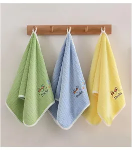 Three colorful soft hanging children's towels with cute duck embroidery on a wooden hook