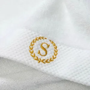 Hochwertiges weißes Hotel-Gästehandtuch aus 100% Baumwolle mit goldenem Sticklogo