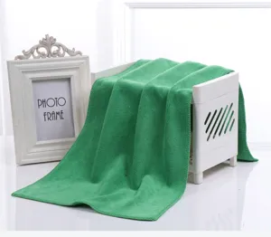 Primo piano di un asciugamano in microfibra verde con morbida consistenza e bordo cucito