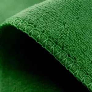 Dettaglio asciugamano in microfibra verde con trama assorbente e bordo con cucitura rinforzata