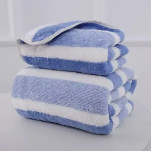 Close-up of a blue and white striped coral fleece towel set with soft plush texture