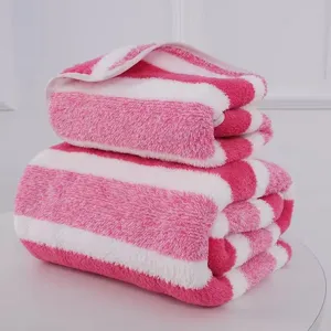 Soft pink and white striped coral fleece bath towel set stacked on a white surface.