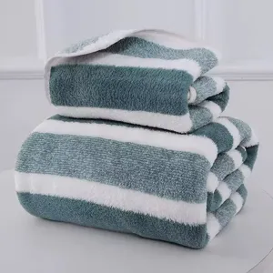 Detailed view of the soft, thick texture on the green and white striped towels.
