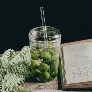 Vaso de vidrio transparente estético con tapa pajita y patrones de estrellas.