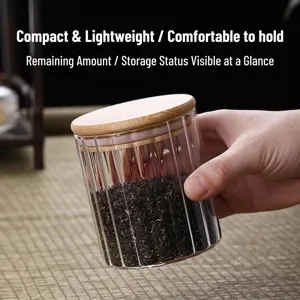Ribbed borosilicate glass storage jar with airtight bamboo lid shown held by hand.