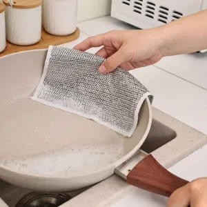 Detailansicht eines langlebigen Metalldraht-Spültuchs beim Reinigen einer Pfanne
