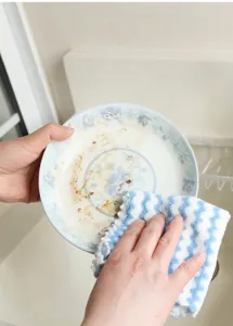 Panno da cucina a strisce blu assorbente che pulisce un piatto di porcellana
