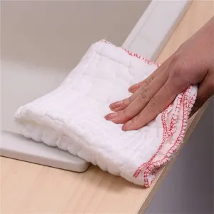 Dettaglio di un panno da cucina in cotone bianco spesso con bordo rosso in uso