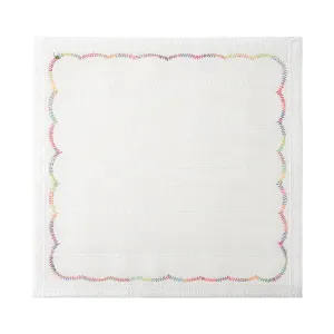 Vista detallada de un paño blanco con bordes bordados en ondas vibrantes de arco iris