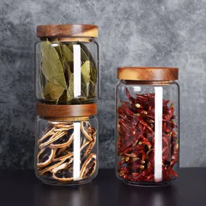 Macro view of glass storage jars with natural acacia wood lids filled with dried spices