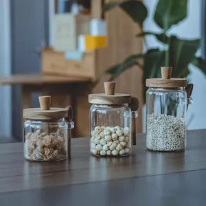 Macro detail shot of three borosilicate glass storage jars with wooden lids and spoons