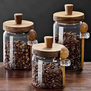 Set of three borosilicate glass storage jars featuring wooden lids and matching spoons