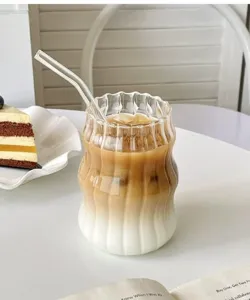 Nahaufnahme eines minimalistischen geriffelten Glases mit geschichtetem Eiskaffee und Milch.