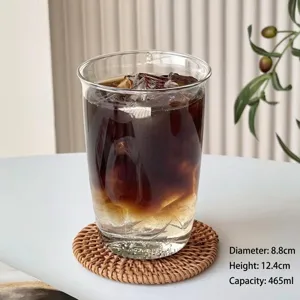 Taza de café de vidrio transparente de 465 ml con hielo en un posavasos tejido blanco.