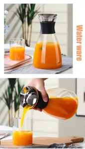 Detail view of glass water pitcher pouring fresh juice, modern home glassware showcase.