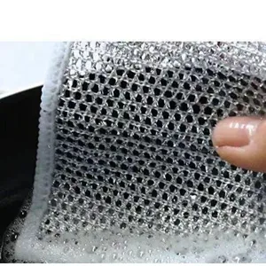 Gros plan d'un lavette en maille d'acier argenté montrant sa texture récurante et mousse
