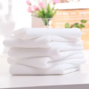 Detailed view of stacked soft absorbent white towels for hotel and salon beauty use