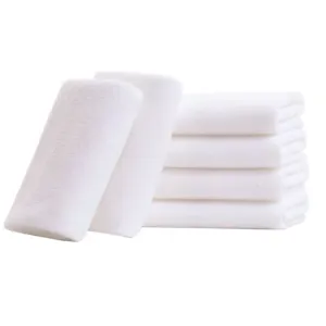 Set of soft white disposable microfiber towels stacked for hotel, spa, and beauty salon use