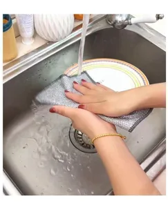 Gros plan montrant le lavage d'une assiette avec un chiffon de cuisine en maille argentée