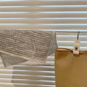 Détail d'un chiffon à vaisselle en fil d'acier argenté montrant la texture alvéolée