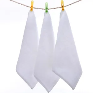 Set of soft white cotton washcloths hanging on a laundry line with colorful clothes clips