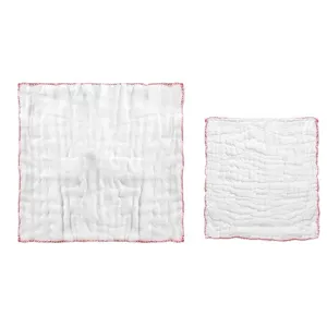 Dos paños de cocina de gasa de algodón blanco con bordes rojos para limpieza absorbente.