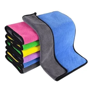 Macro detail of thickened microfiber coral fleece towels in multiple vibrant colors.