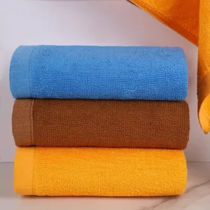 Close-up of three stacked colorful cotton towels showing soft terry cloth texture