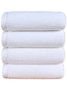Detail of four stacked white hotel-quality absorbent cotton towels with soft texture