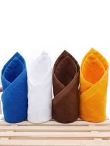 Detailed view of four absorbent cotton towels in blue, white, brown, and orange colors