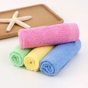 Close-up of four rolled-up absorbent wood fiber dishcloths in pink, blue, green, yellow