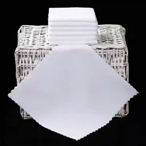 Detailed shot of disposable white square towels stacked on a basket for hotel and restaurant