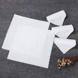 Set of absorbent white disposable square towels with scalloped edges for restaurant use