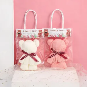 Set of two bear-shaped coral fleece towels in pink and white gift bags for wedding favors