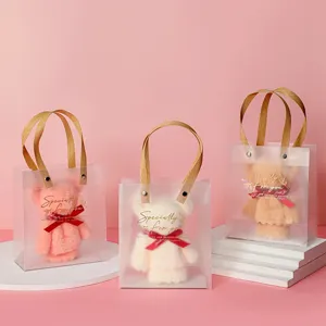 Cute bear-shaped coral fleece towels in frosted gift bags for wedding favors and parties