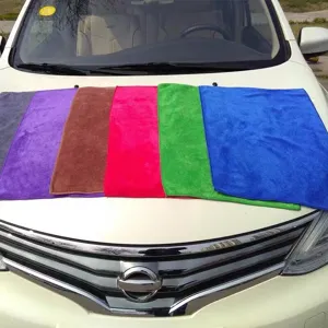 Detailed view of colorful absorbent microfiber car cleaning towels on a white vehicle