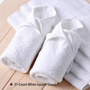 Close-up detail of premium soft white 21s cotton square towels on wooden surface