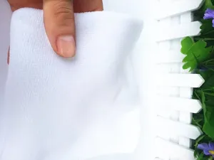Macro detail of a white lint-free microfiber cloth showing the soft fiber texture.