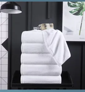 Close-up of a stack of five premium white hotel bath towels in soft pure cotton