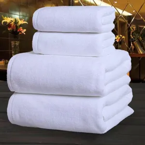 Detailed view showing the texture of thick white cotton bath towels stacked neatly