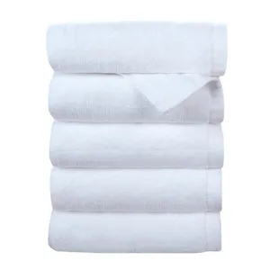 Premium stack of five absorbent pure white cotton towels for hotels and salons use