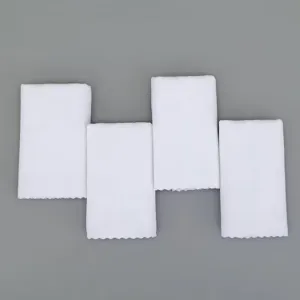 Set of 4 disposable white absorbent towels with scalloped edges on grey background