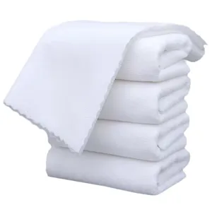 Professional stack of five white disposable absorbent warp-knitted soft towels for spa use