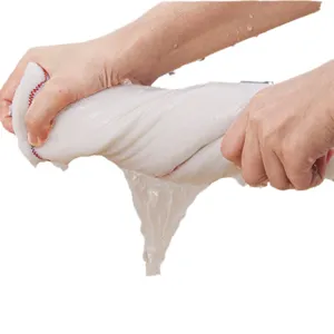 White microfiber kitchen cleaning cloth being wrung out by hands with water dripping