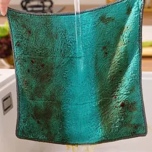 Detail of a teal microfiber cleaning cloth being rinsed under running water in a sink.