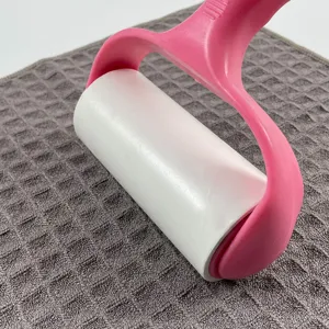 Close-up of pink lint roller cleaning grey waffle weave microfiber cloth