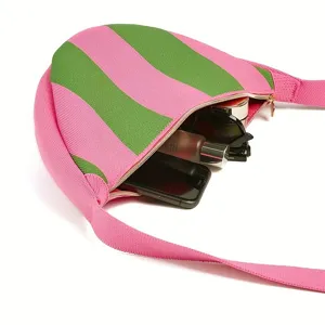 Interior view showing the capacity of this pink and green striped knitted crossbody bag