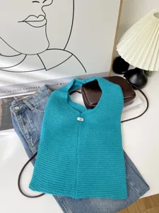 Detailed view of teal knitted tote bag with 'egg.' tag on minimalist lifestyle background