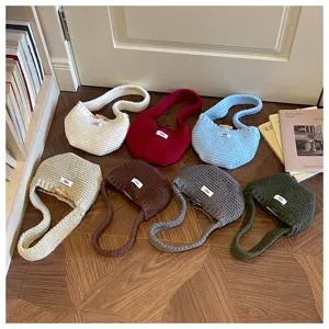 Variety of colorful knitted mini clutch bags and earphone pouches on wooden floor