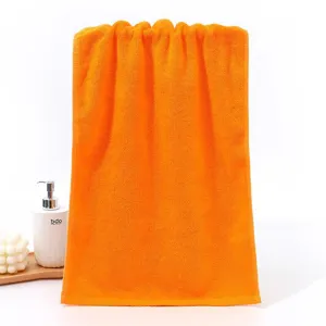 Close-up of soft orange cotton towel with absorbent looped texture for home use